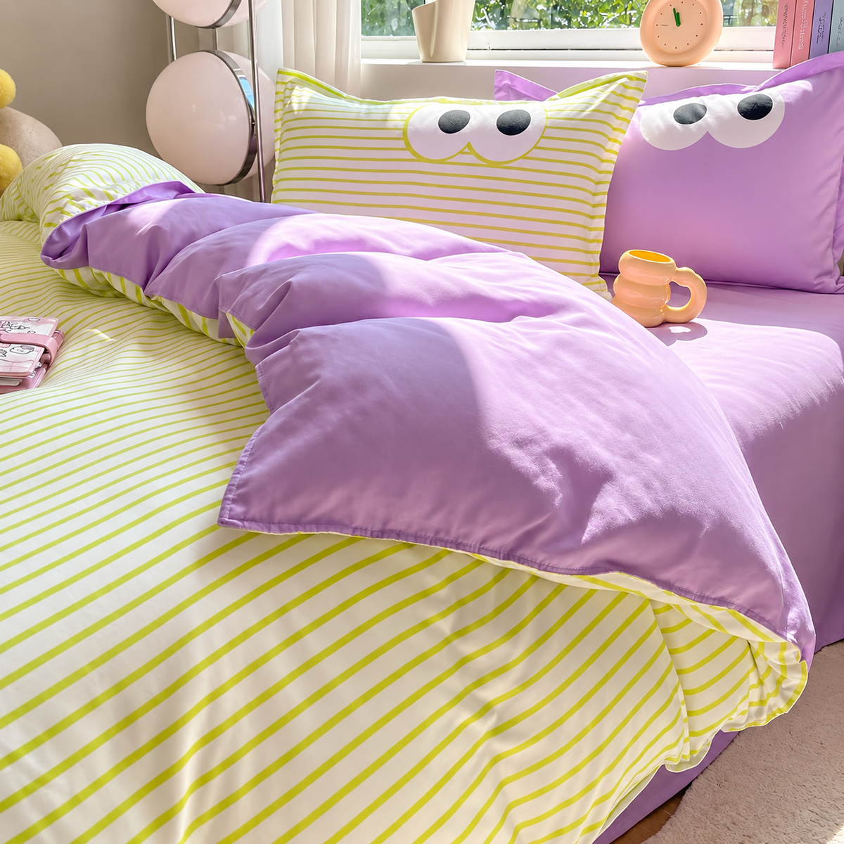 A cozy bed styled with a pastel purple and yellow bedding set. The duvet cover features thin yellow stripes on a white background, while the matching pillowcases and solid pillow shams are lavender purple.