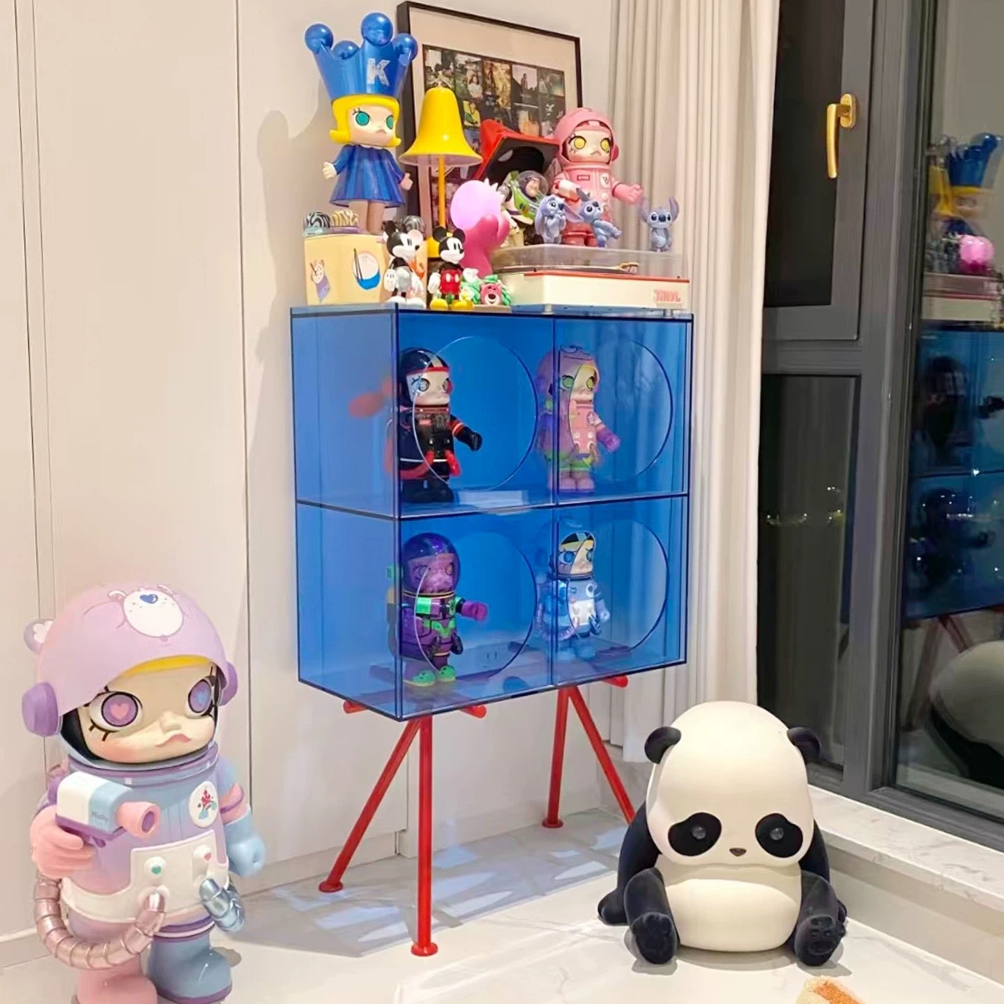 Acrylic display cabinet showcasing figurines in modern living room with minimalist transparent storage design