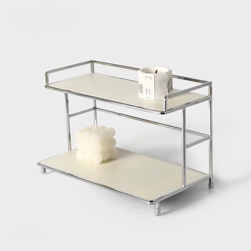 Two-tiered metal and leather serving cart with candles on a white background