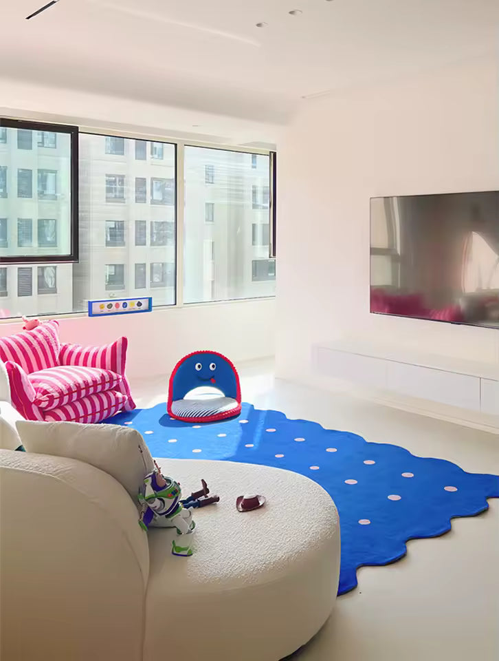 Modern living room with a blue octopus-shaped rug, white sofa, and toy on a light-colored floor.