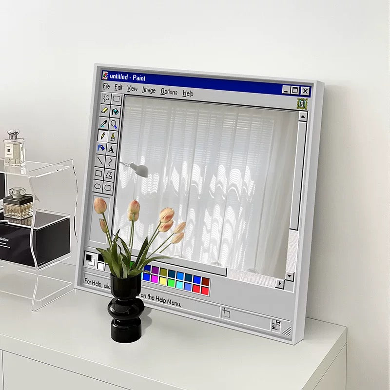 Vintage computer monitor with a flower arrangement on a white surface