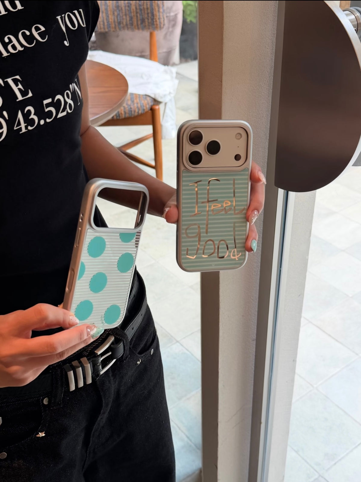 Two aqua striped iPhone cases are held upright, with the empty polka dot case beside the Feel Good design.