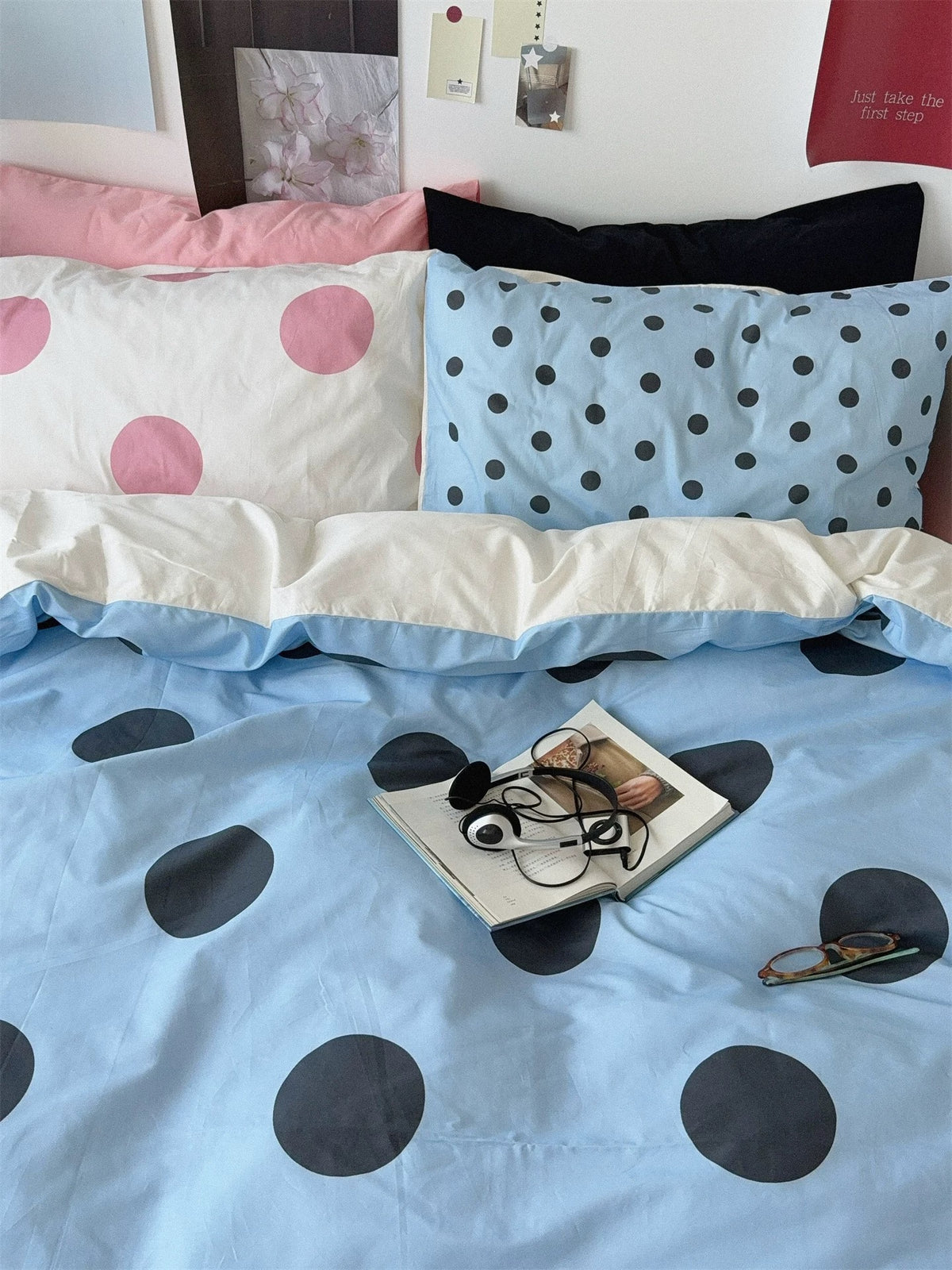 A close front view shows pink dotted and small blue dotted pillowcases above the folded blue cover.