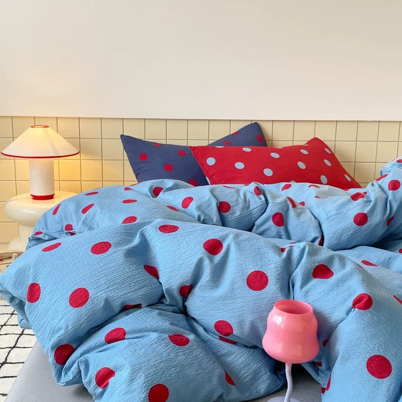 Blue polka dot bedding featuring bold red dots, perfect for teen girl bedrooms and modern dorm room decor.