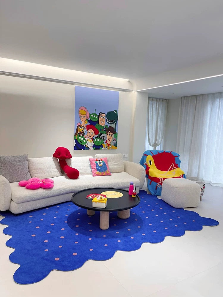 Children's playroom with a blue rug, white sofa, and colorful toys.