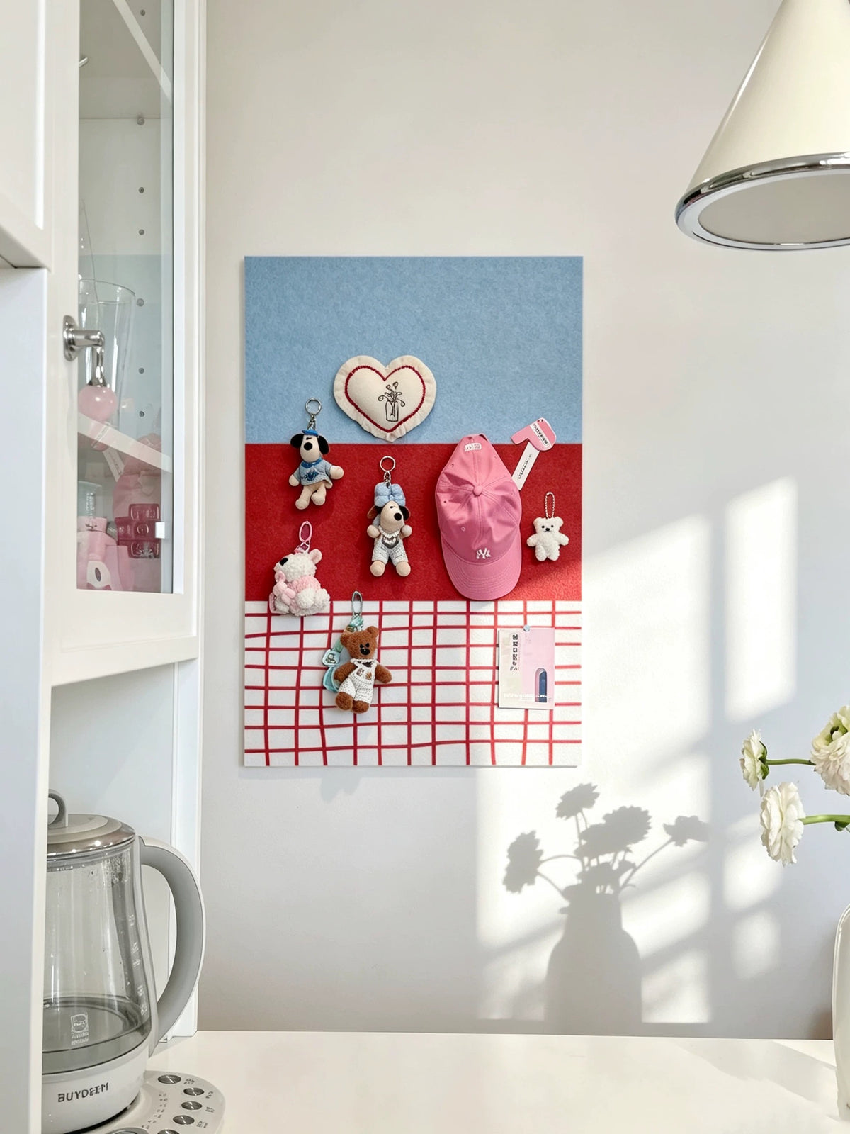 Blue and red checkered felt pin board displayed in a bright room near shelving and a window