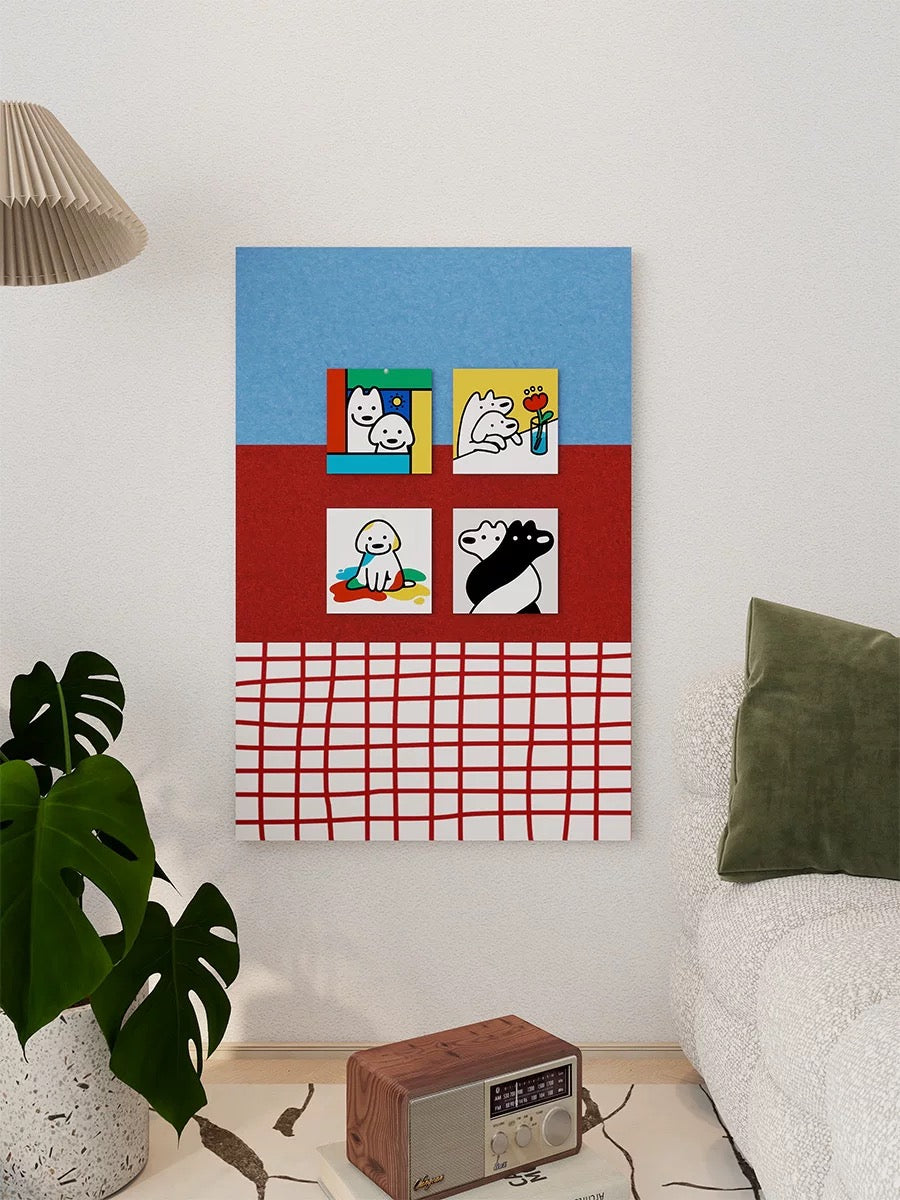 Blue and red felt pin board with four pinned art cards above a small table beside a plant and bed