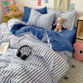 Minimalist small apartment styled with a blue stripe bedding set and cozy rug.