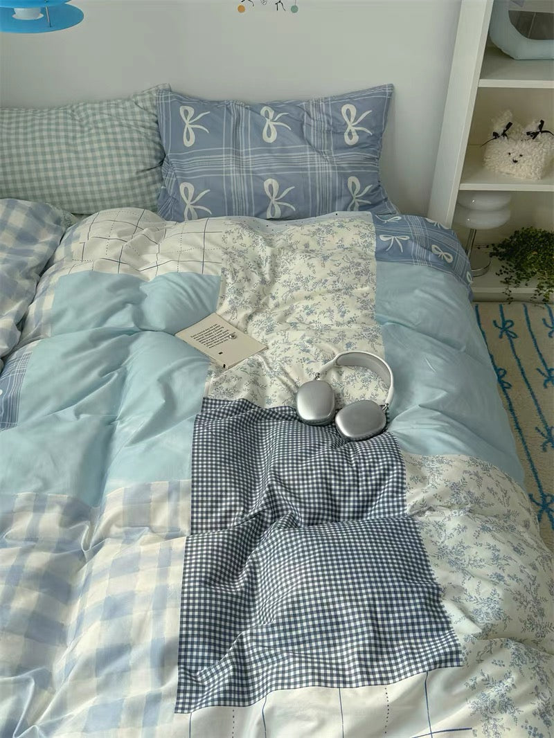 Bedding set with checkered and floral patterns on a bed in a room.