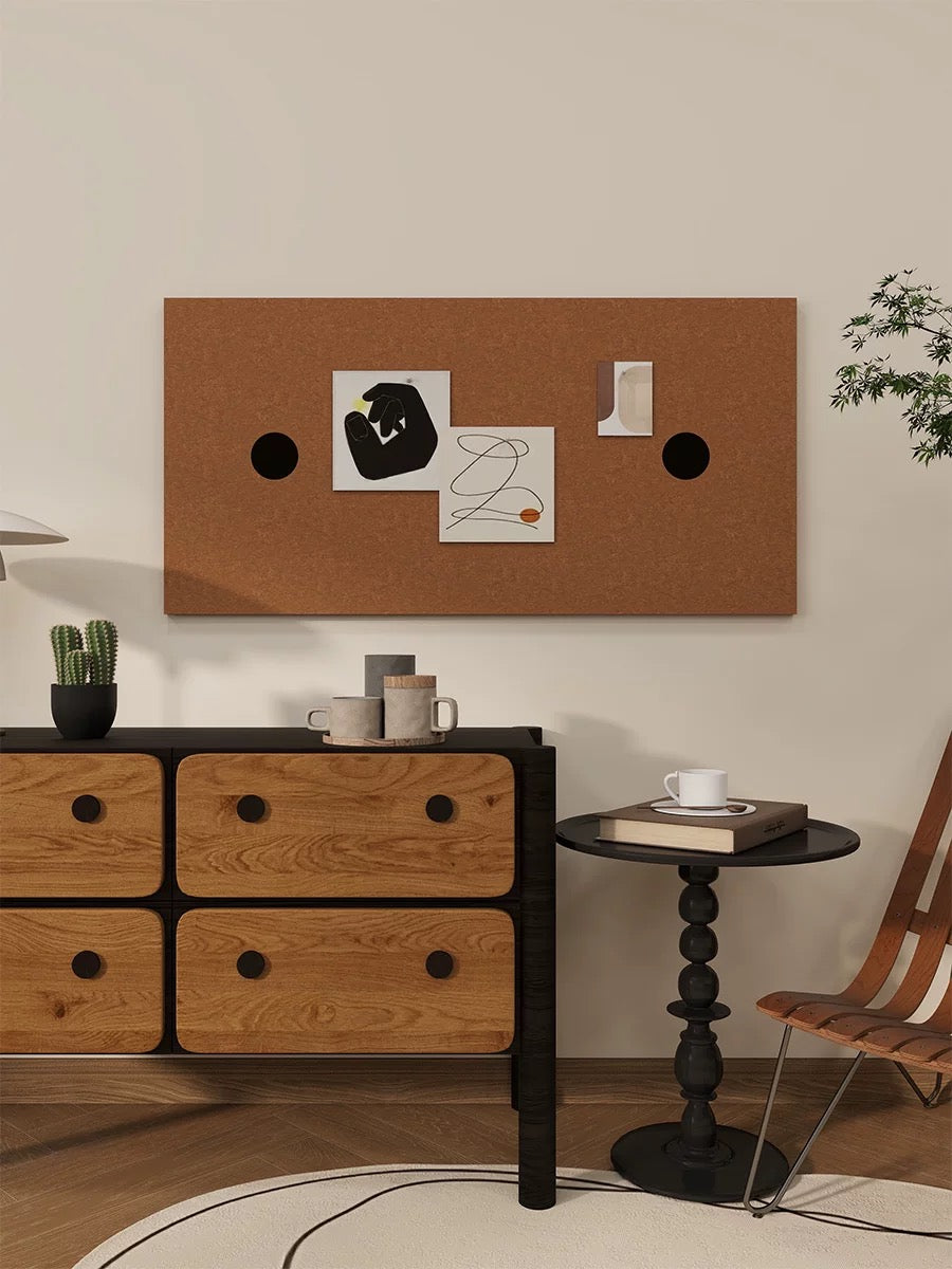 Bronze dotted bulletin board displaying photos above a wooden drawer cabinet.