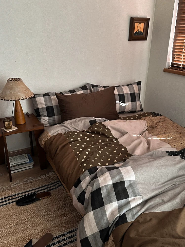 Brown plaid bedding with checked pillowcases and a wooden bedside table