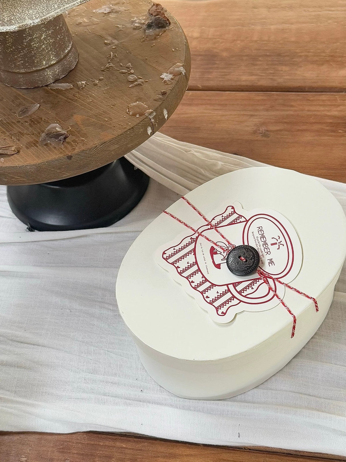 Closed scented candle gift box displayed on a wooden tabletop