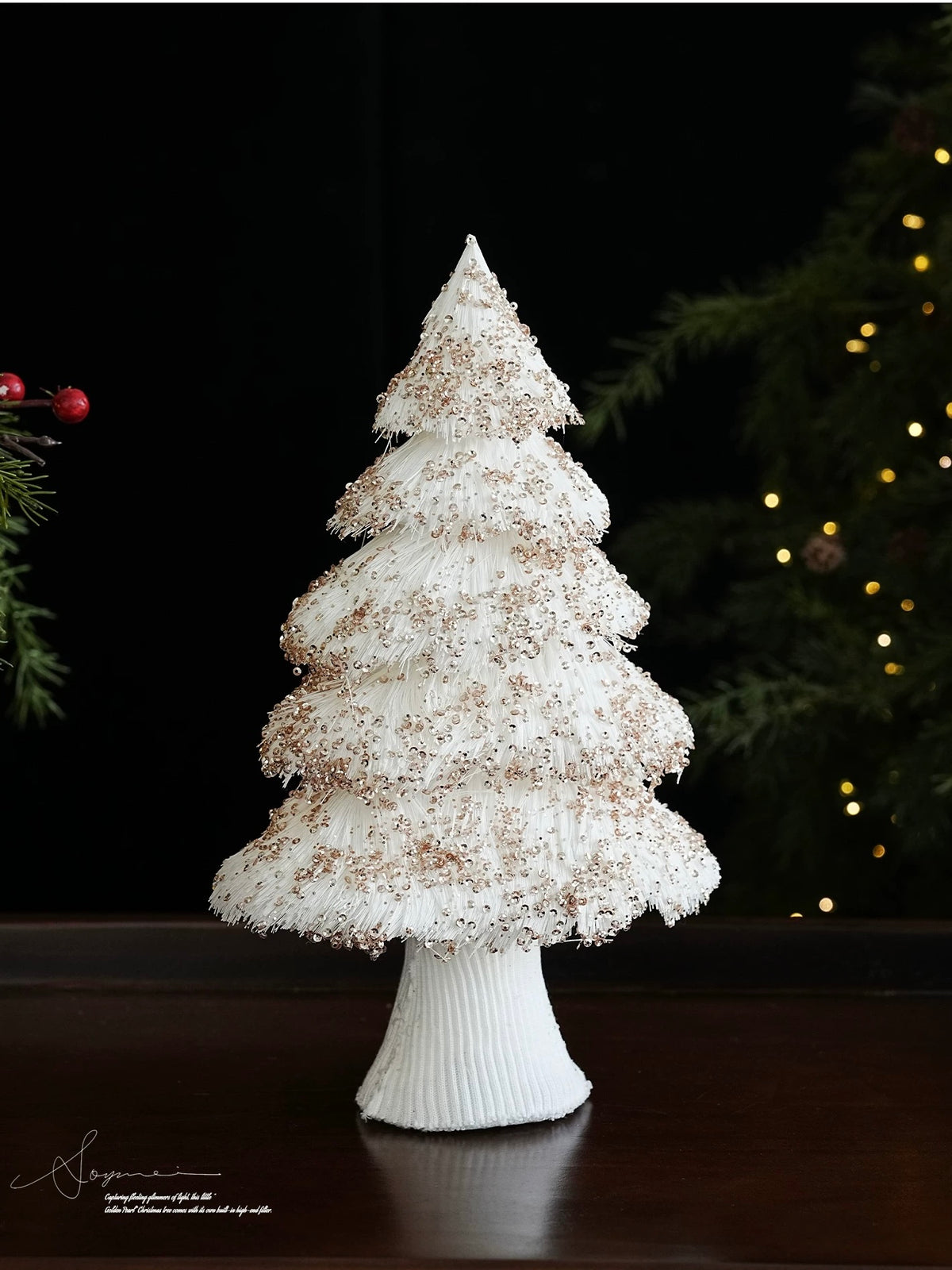 A champagne sequin Christmas tree stands upright, showing pale gold accents across its white fringed branches.