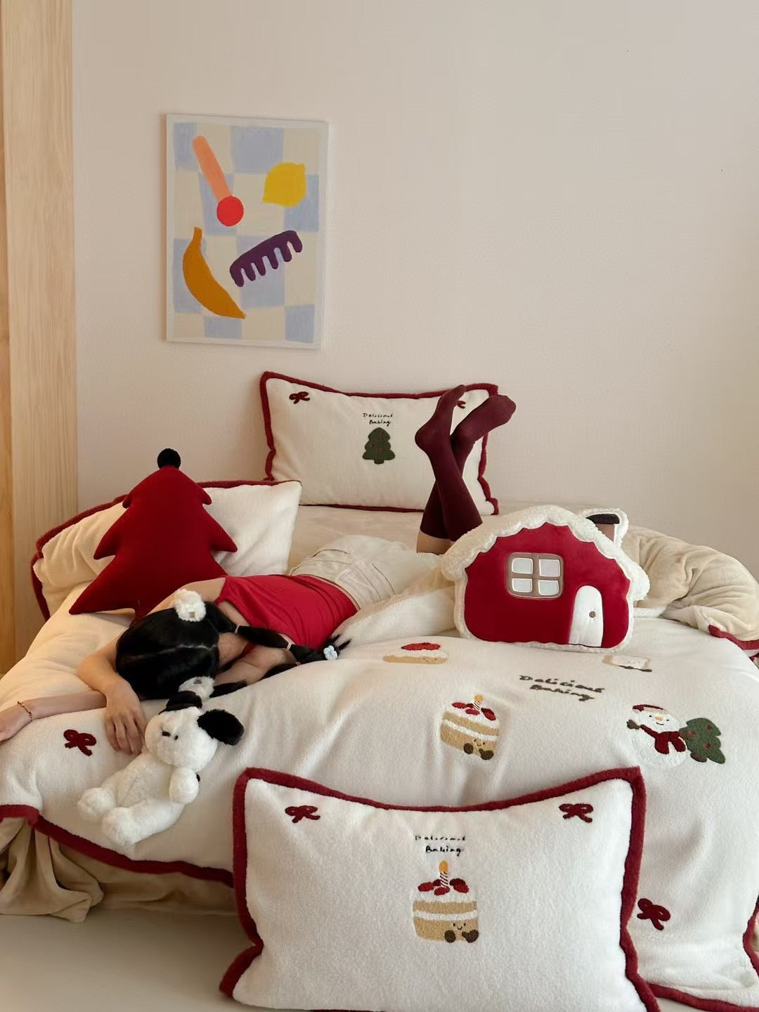 Red bow Christmas bedding set styled on a white bed with embroidered holiday motifs