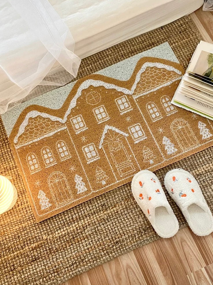 Christmas gingerbread house doormat styled on a woven rug with white slippers