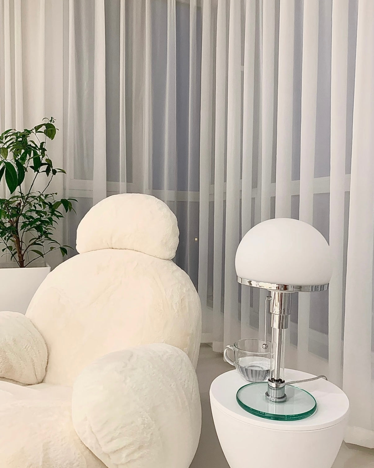 Warm light bedside lamp with mushroom shade, chrome detail, and transparent glass circular base.