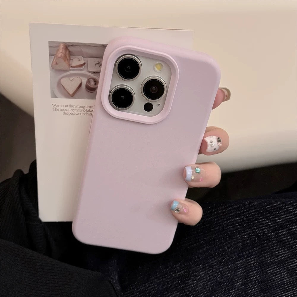 Person holding a phone with a pink case, blurred magazine in the background