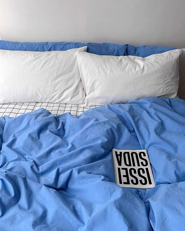 Blue bedding with a visible brand label on a bed.