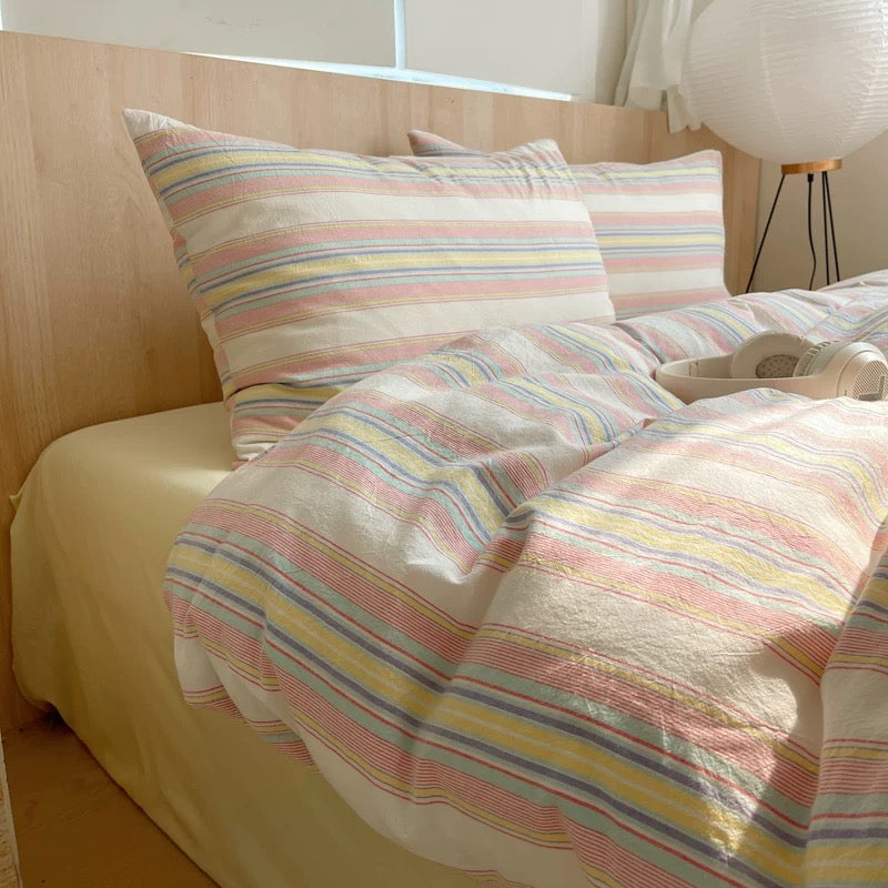 Bed with striped bedding and pillows in a bedroom setting