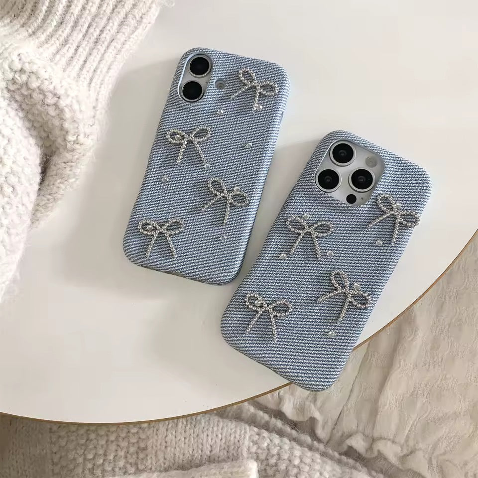 Two blue phone cases with bow designs on a white surface.