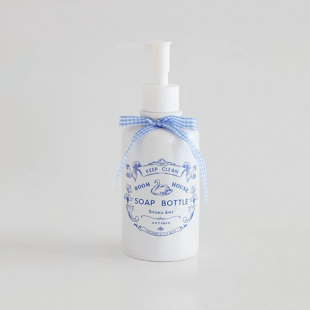 Coquette soap dispenser has a blue gingham bow tied around the neck above blue swan and floral artwork.