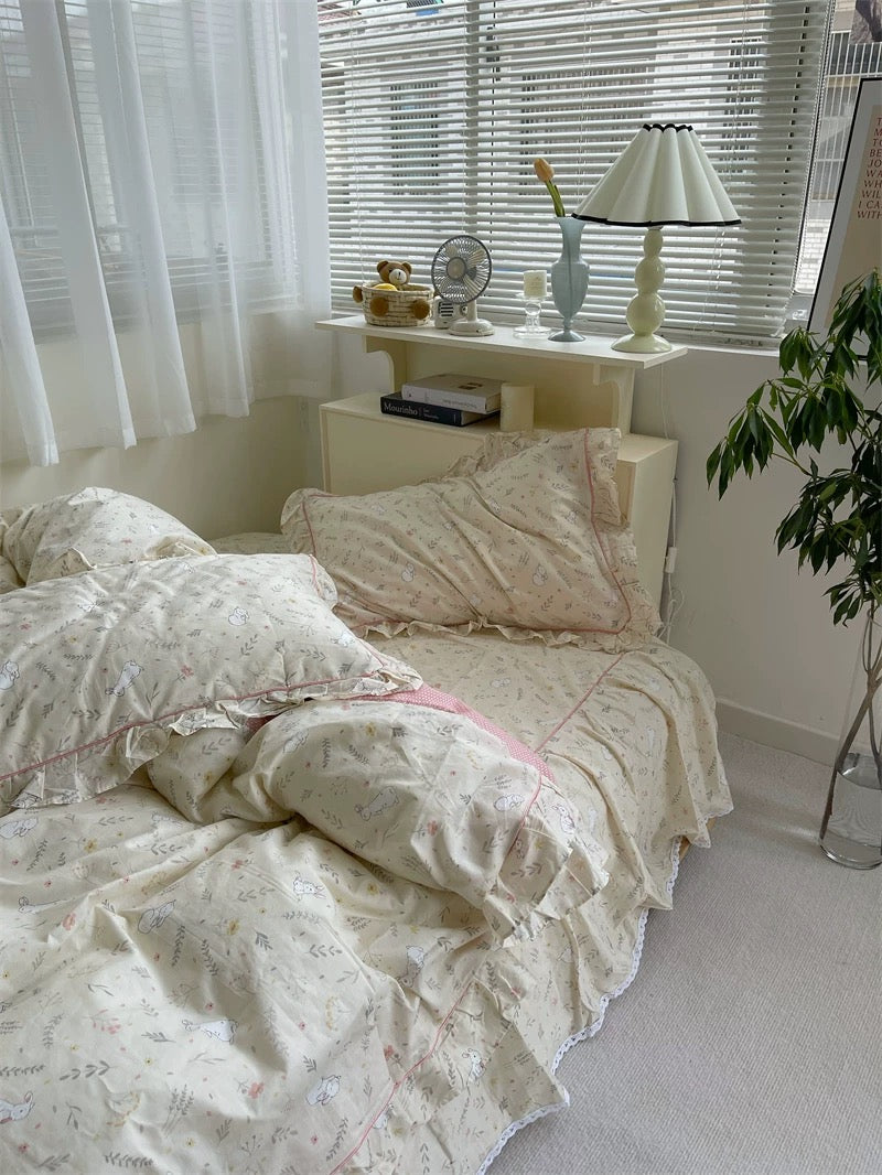Cream bunny print cotton bedding set with ruffle edges styled in cozy coquette aesthetic bedroom interior.