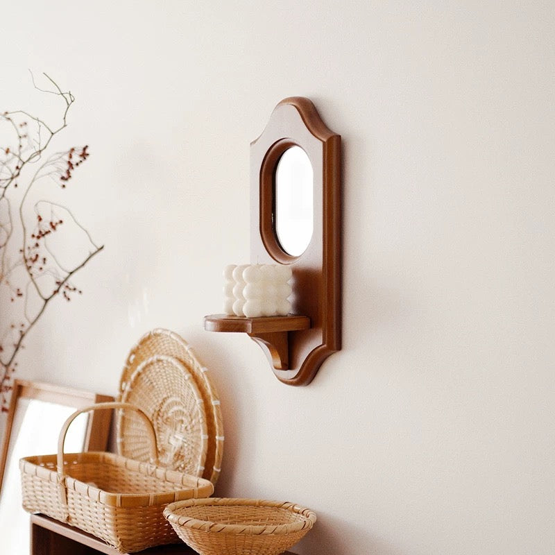 Wooden wall-mounted candle holder with a white candle on a light gray background
