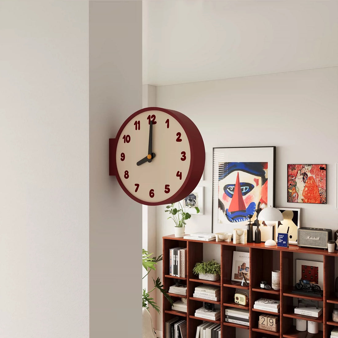 Wall clock on a shelf with decorative items against a light gray wall