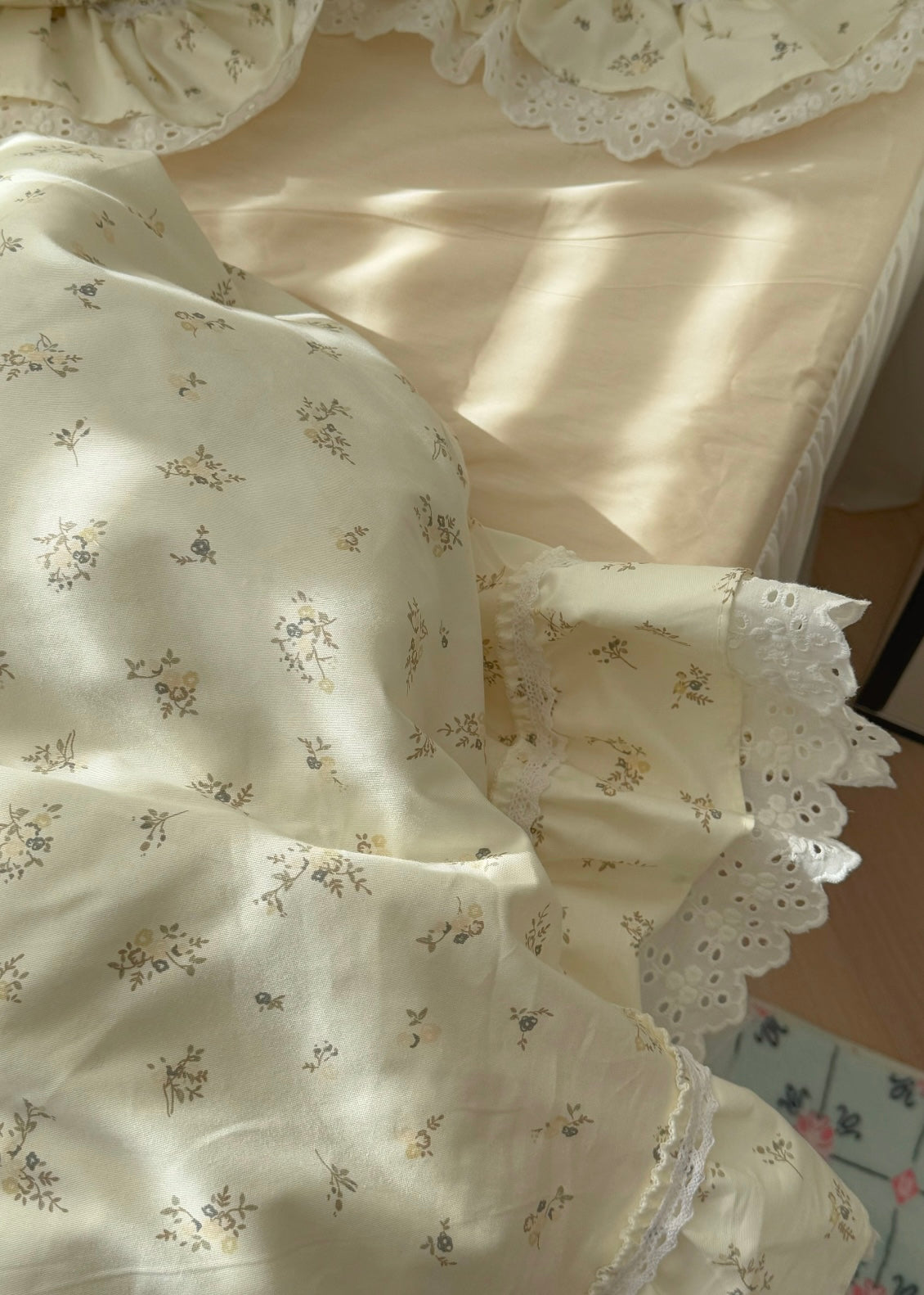 Floral-patterned fabric with lace trim on a light background