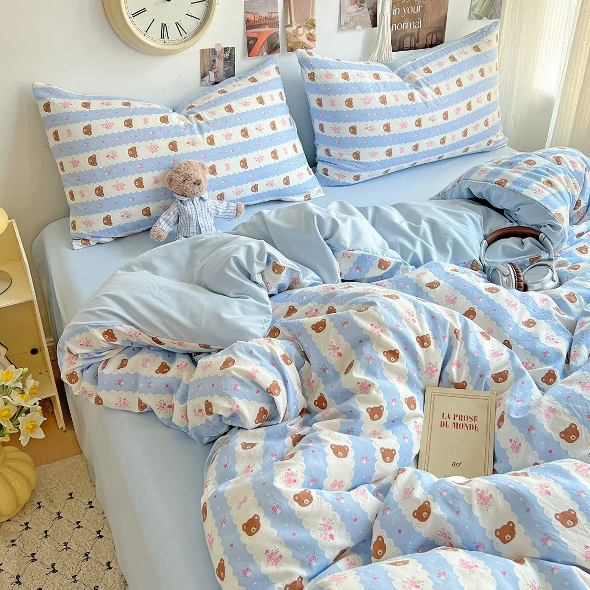 Kawaii teddy blue bedding styled with fairy lights and soft pink accessories.