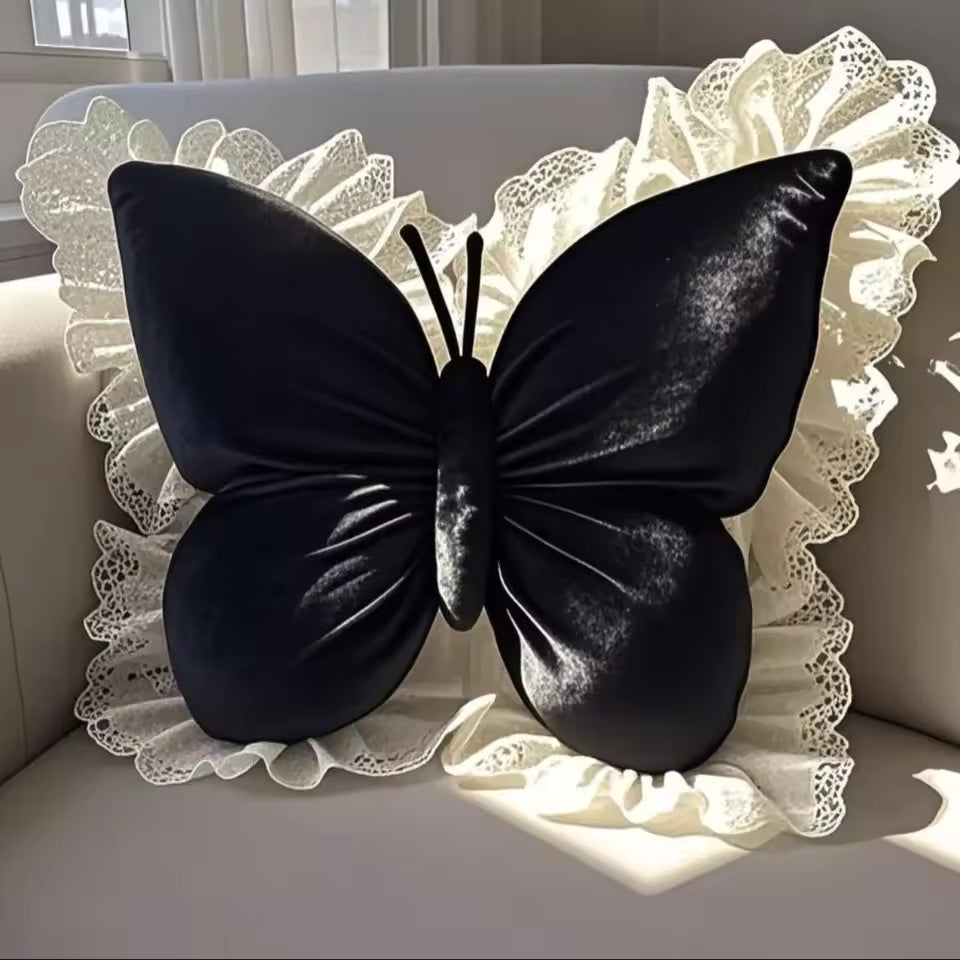 Black butterfly-shaped pillow on a decorative white cushion