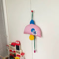 Colorful children's toy organizer hanging on a white door with toys on the floor below.
