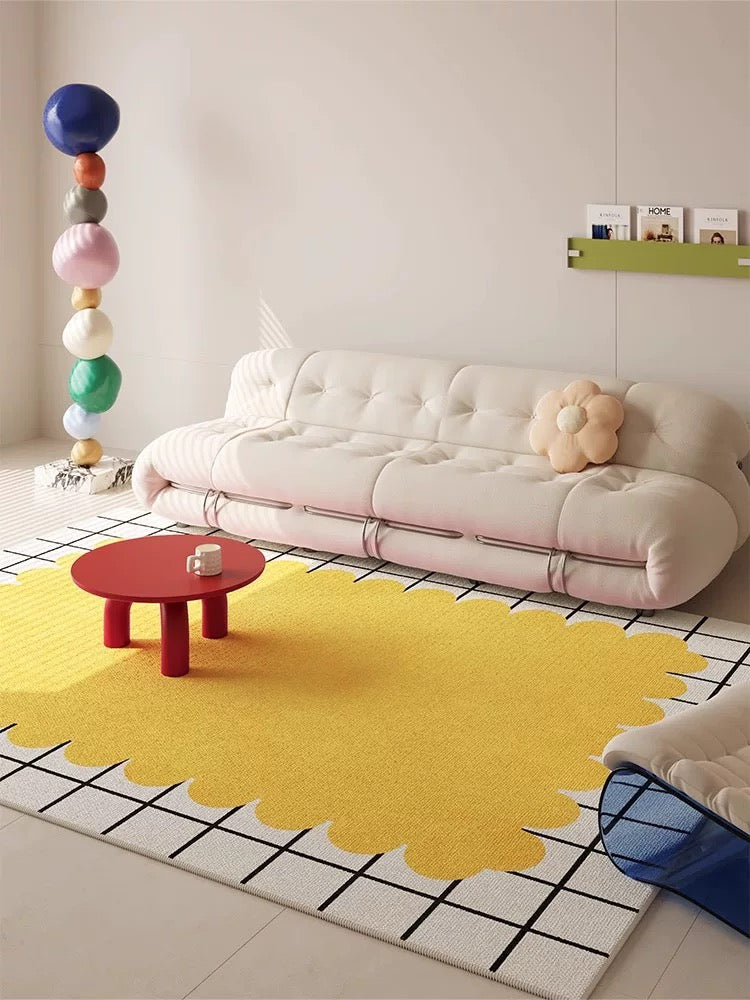Modern living room with a yellow rug, white sofa, and colorful decor.