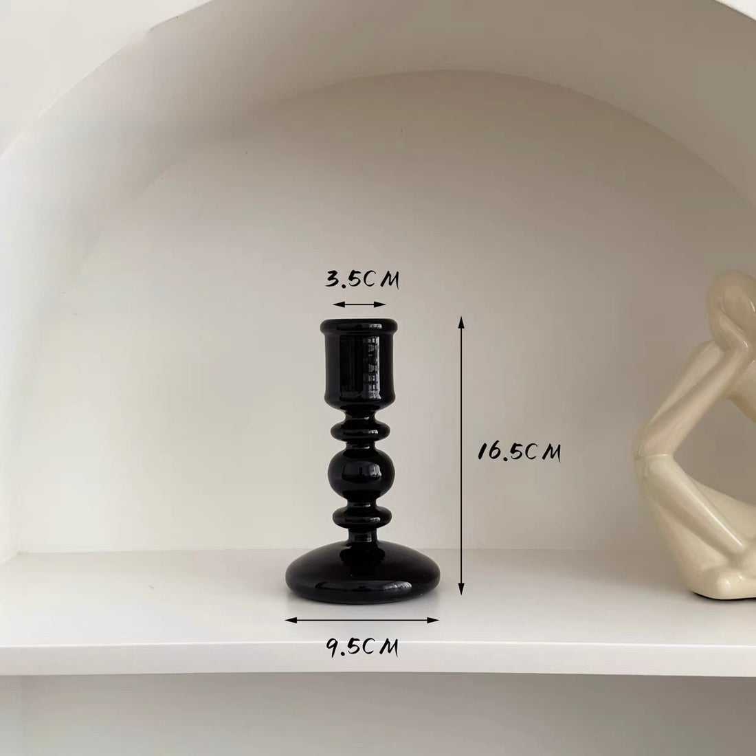 Set of black candle holders on a table with a neutral background