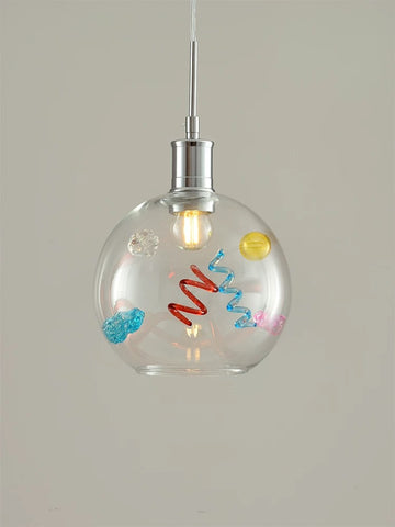 Clear glass pendant light with colorful decorations on a neutral background