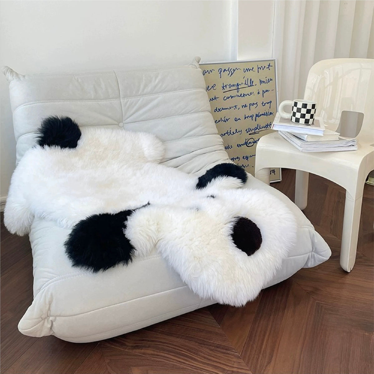 A white dog shaped rug covers a lounge chair, showing black ears, a dark nose and a rounded body.