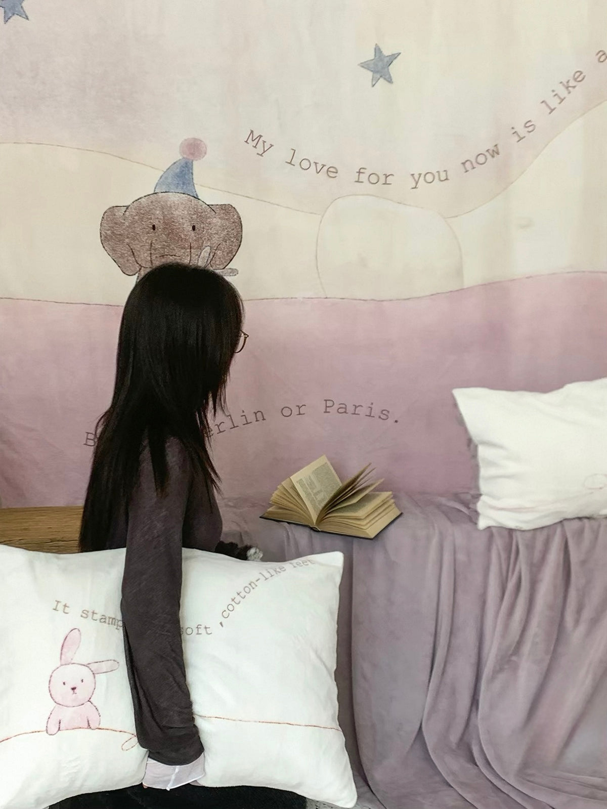 The elephant and star cover hangs above a purple-draped seat and illustrated pillowcase.