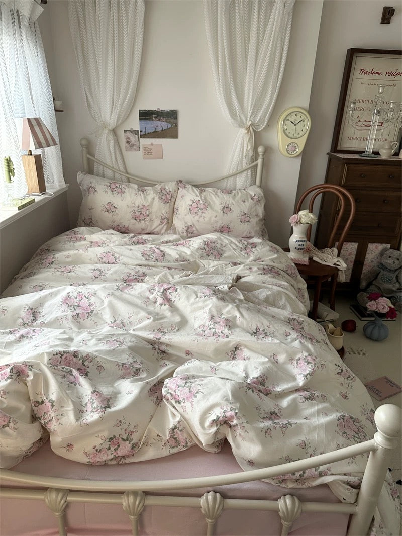 Romantic blush floral bedding arranged with vintage furniture creating elegant French country inspired interior for relaxation daily.