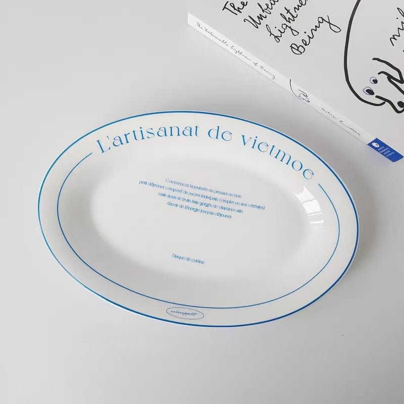 Oval white ceramic serving plate with blue French lettering double rim and gently raised edge