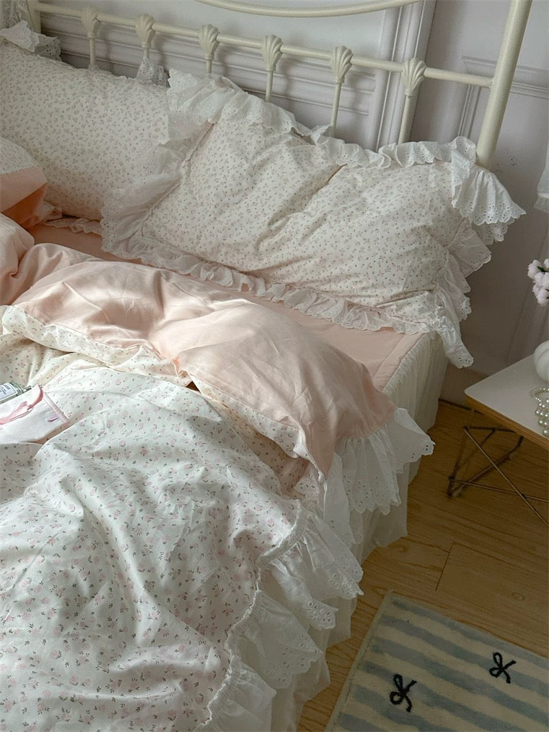 Bed with floral bedding and ruffled edges in a softly lit room.