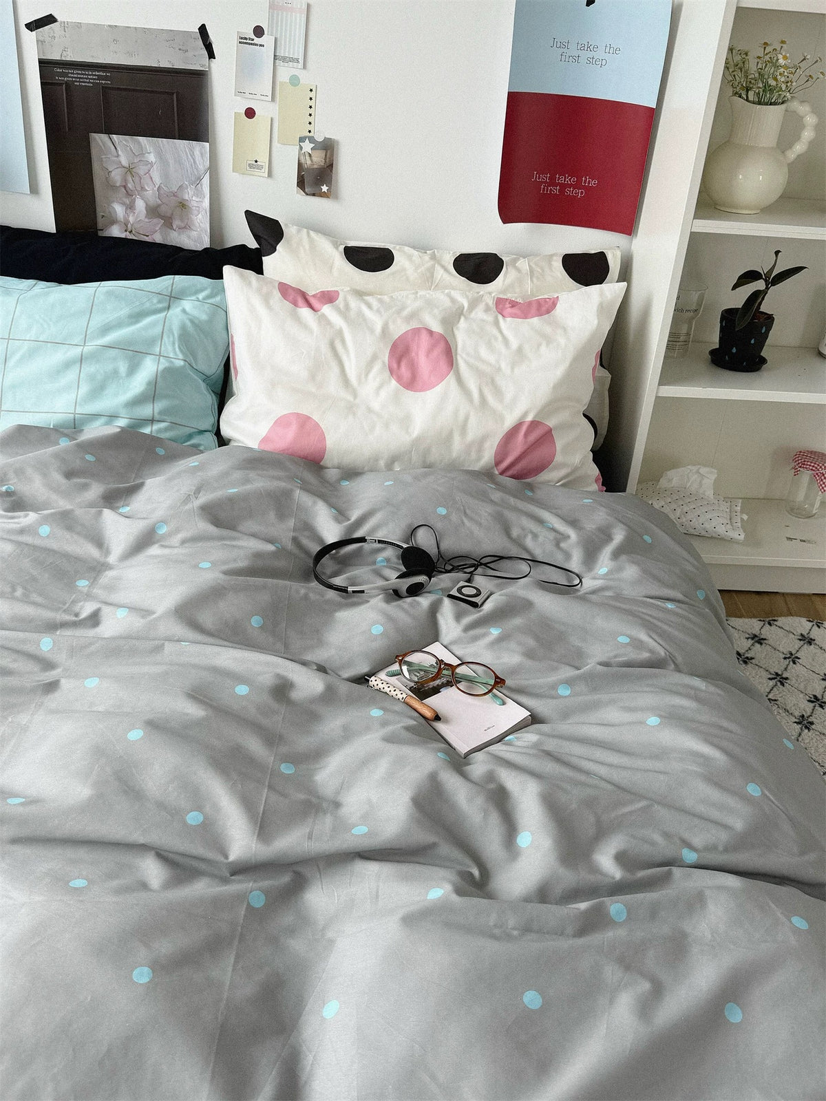 Gray duvet cover with pale blue dots below pink and black dotted pillowcases.
