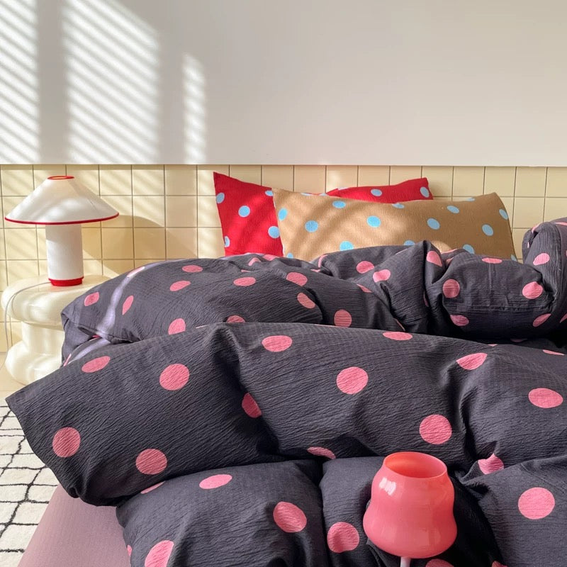 Preppy dorm room bedding featuring charcoal polka dot duvet cover and playful pink details