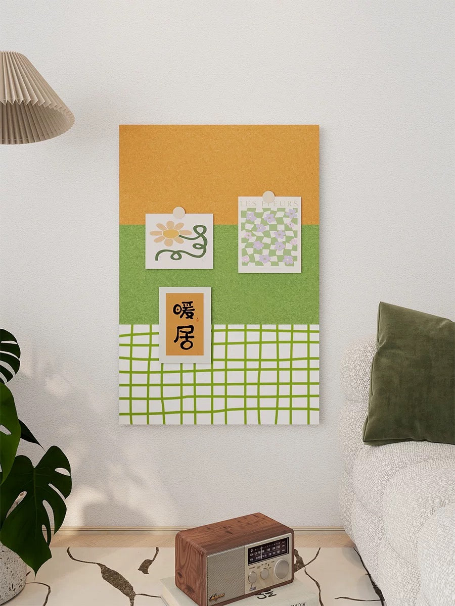 Green checkered felt pin board with pinned notes and art above a small table beside a bed