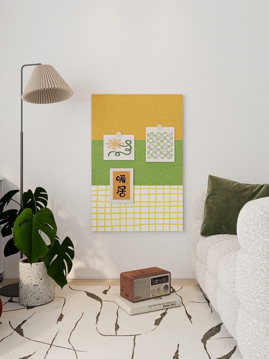 Green felt pin board styled on a bedroom wall beside a plant, small table, and bed