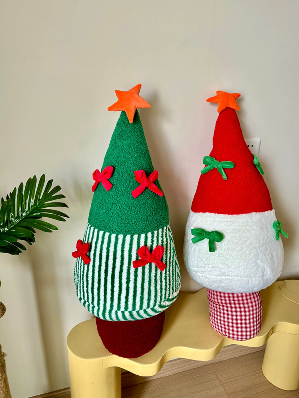Green and red Christmas tree pillows styled together as festive room decor