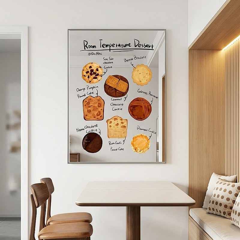 A framed wall art print showing a dessert temperature chart with illustrated baked goods and handwritten labels, displayed above a dining table in a modern interior setting.