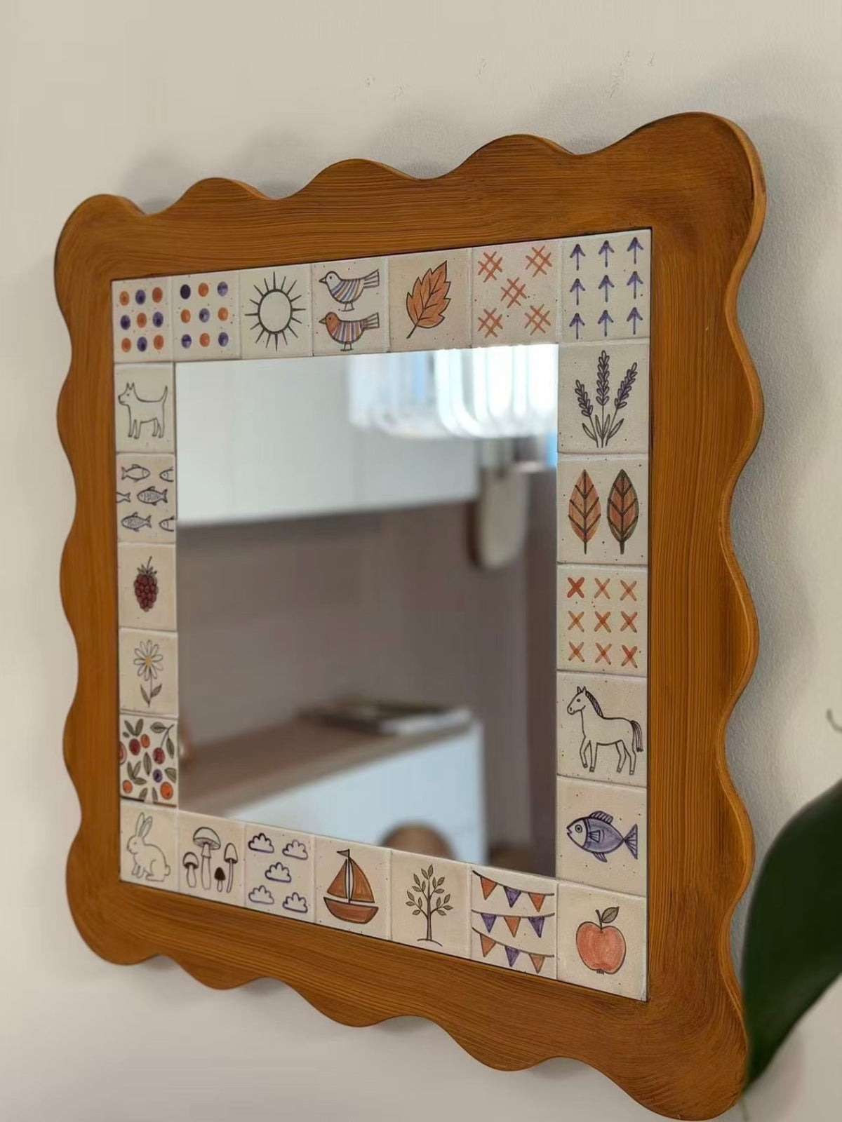 An illustrated scalloped mirror is shown at an angle, with a brown outer frame and its square glass center.