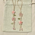 Decorative bookmarks with floral and star designs on a textured fabric background
