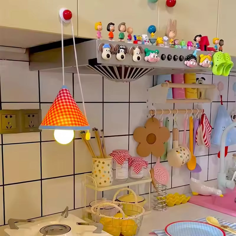 Children's kitchen set with colorful toys and utensils on a tiled wall.