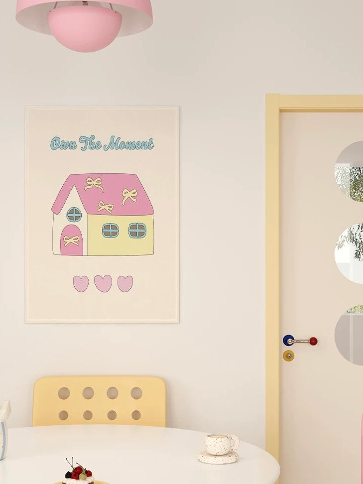 A Kawaii tapestry shows a pink roof, blue windows and pink hearts above a yellow chair and white table.